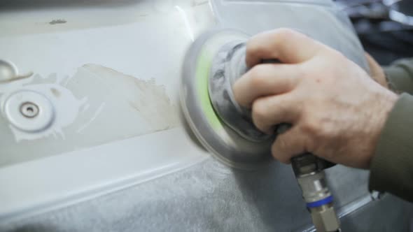 polishing of the damaged car door with a grinder