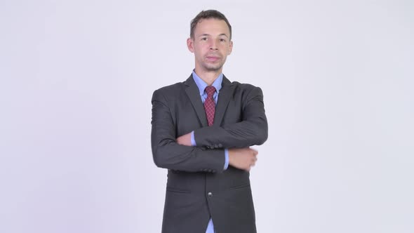 Studio Shot of Happy Businessman with Arms Crossed