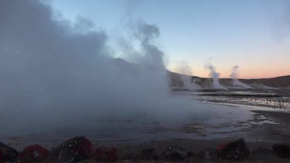 Boiling geysers with steam rising to the sky in Iceland.