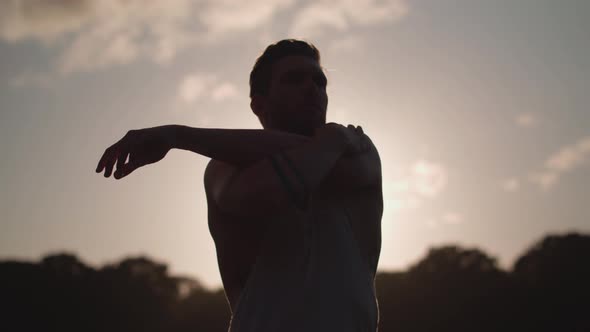 Young Attractive Man Stretching In Park Before He Works Out