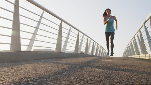 Young woman running on a bridge