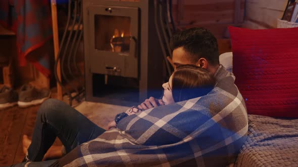 Couple Sitting By the Burning Fireplace in a Cozy House