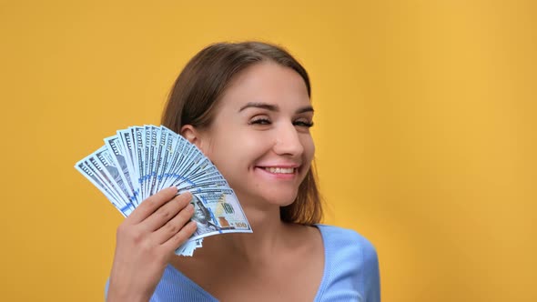 Closeup Laughing Woman Waving Cash Dollar Fan Financial Success Richness Posing Isolated on Orange