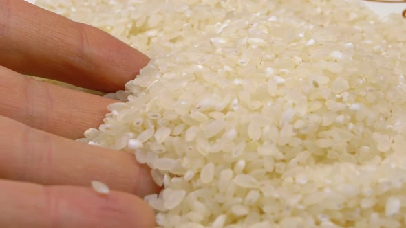 Human Hand Taking Pinch of Raw Rice