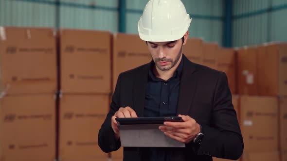 Factory Manager Using Tablet Computer in Warehouse or Factory