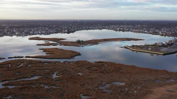 An aerial shot over Baldwin Bay near Freeport, NY during sunset. The drone camera dolly in high over