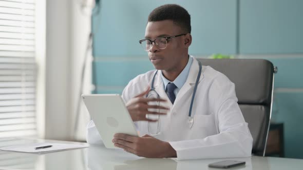 Young African Doctor Making Video Call on Tablet in Office