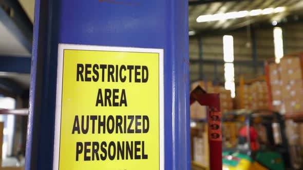 Yellow Restricted Area Sign In Warehouse