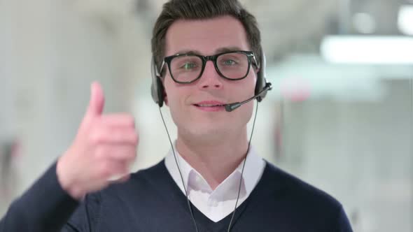 Young Businessman with Headset Showing Thumbs Up