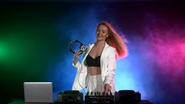 Beautiful, Smiling Dj Girl in White Jacket, Headphones Playing Music and Dancing, Smoke