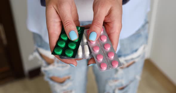 Anonymous woman with blister pack of pills in hands , close up of medicament dose pill,