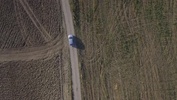 Drone view of a car driving in the countryside