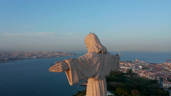 Big Stone Statue of Jesus Illuminated By Last Sun Rays of Day