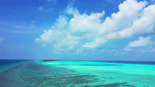 Wide angle fly over clean view of a white sand paradise beach and blue sea background in colorful 4K
