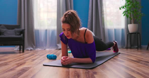 Strong Beautiful Fitness Girl in Athletic Workout Clothes is Doing a Plank Exercise