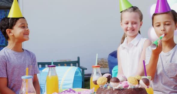 Boy blowing party horn during birthday party 4k alt