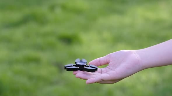 Asian Child  Playing  Fidget Spinner On Nature Background,Slow Motion