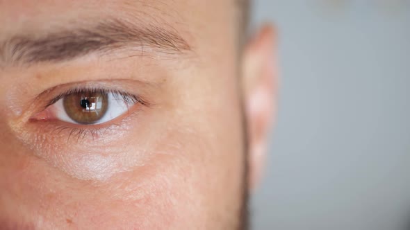 Slow Motion of Male Eye Close Up From Young Man Half Face