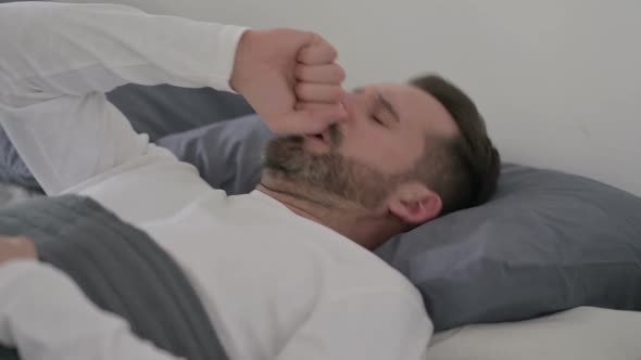 Man Coughing While Sleeping in Bed