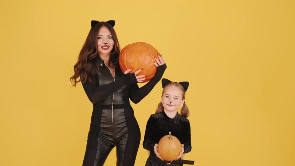 Mother and Daughter with Wearing Halloween Costumes Have in Orange Studio