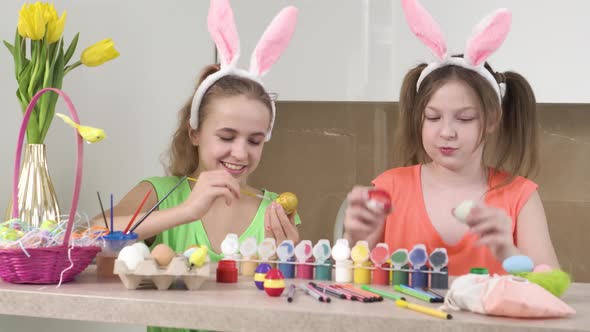 Two Cute Girls Play and Show the Camera Decorated Easter Eggs