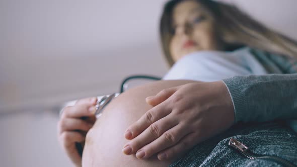 Pregnant Lady Uses Stethoscope To Examine Baby Close View