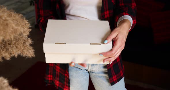 Brunette Woman Opening Online Order Parcel Box with Cosmetics at Home