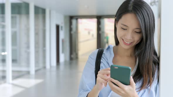 Young woman use of mobile phone inside building