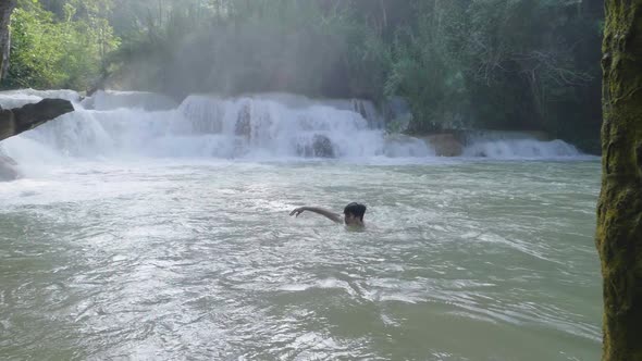 Man Swimming At Waterfall