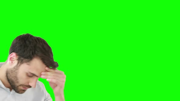 Worried man standing against green screen