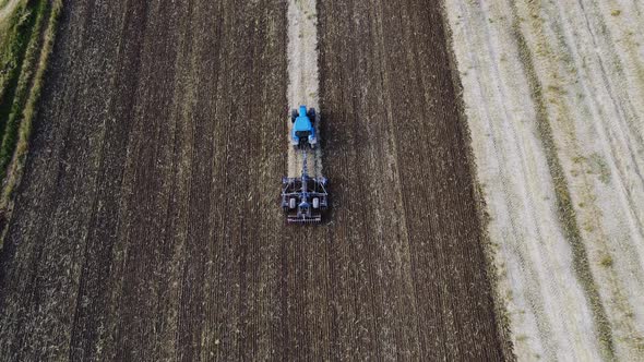 Tractor Plows Ground on Cultivated Farm Field