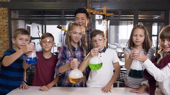 Korean Male Teacher with Group of Six Cheerful Young Caucasian Students Wearing Goggles