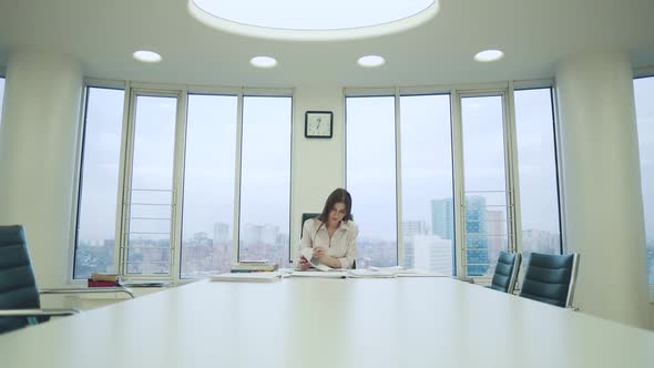 Young Woman Works with Documents in the Office
