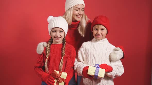 Cheerful Happy Woman with Daughter and Son Holding Gifts for New Year 2021