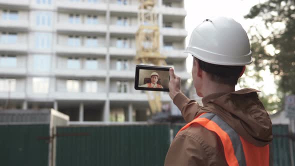 A civil engineer conducts a video conference with a chief civil engineer at a construction site.