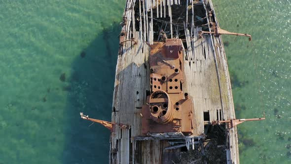 A Wrecked Wooden Ship Lies on the Seashore Covered with Rust