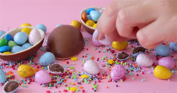 Female Hand Took Easter junk-food, chocolate eggs