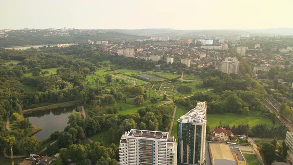 Aerial drone view of Dendrarium Park with lush greenery and lake. Panorama view of multiple building