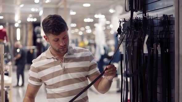 Male Buyer Selecting Leather Belt in Store