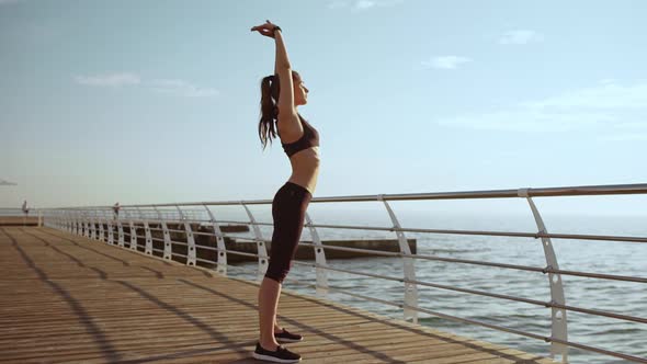 Young Beautiful Sportive Girl Training at Seaside