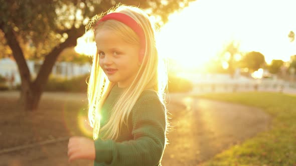 Happy Little Boy Dancing and Listening to Playlist Music with Headphones Outdoor at City Park