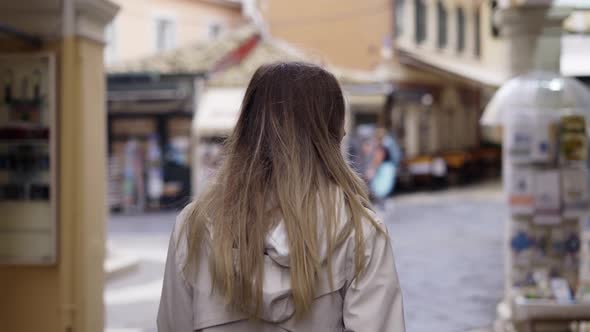 A Woman Walks Along an Old City Street Looks Around at the Sights