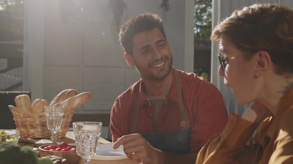 Man and Woman Sitting at Table and Talking