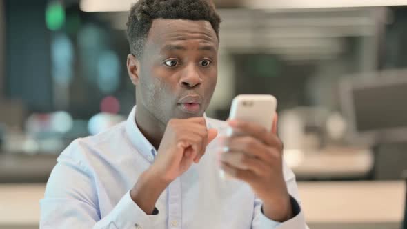 Portrait of African Businessman Celebrating on Smartphone