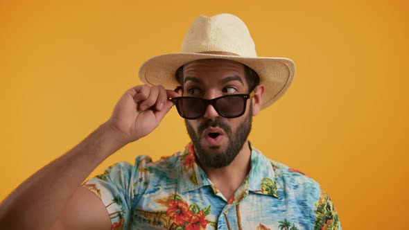 Studio Shot of Confident Handsome Cuban Bearded Man in Vacation Colorful Shirt and Hat Taking Off