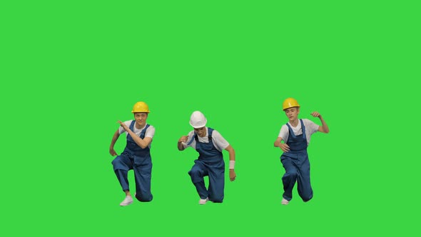 Three Young Construction Workers in Hard Hats Synch Dancing Looking at Camera on a Green Screen