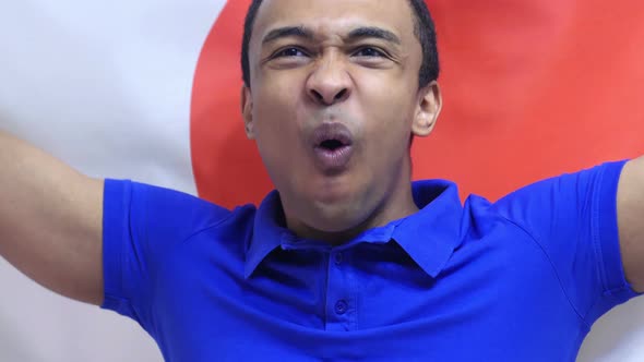 Japanese Fan Celebrates Holding the Flag of Japan