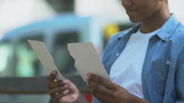 Broken-hearted Afro-American teen boy putting together two pieces of photo