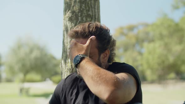 Tired Sportsman Wiping Sweat From Forehead After Workout