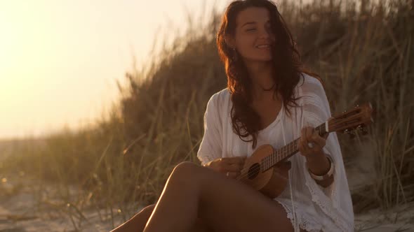 Woman With Ukulele During Summer Beach Vacation Near the Sea